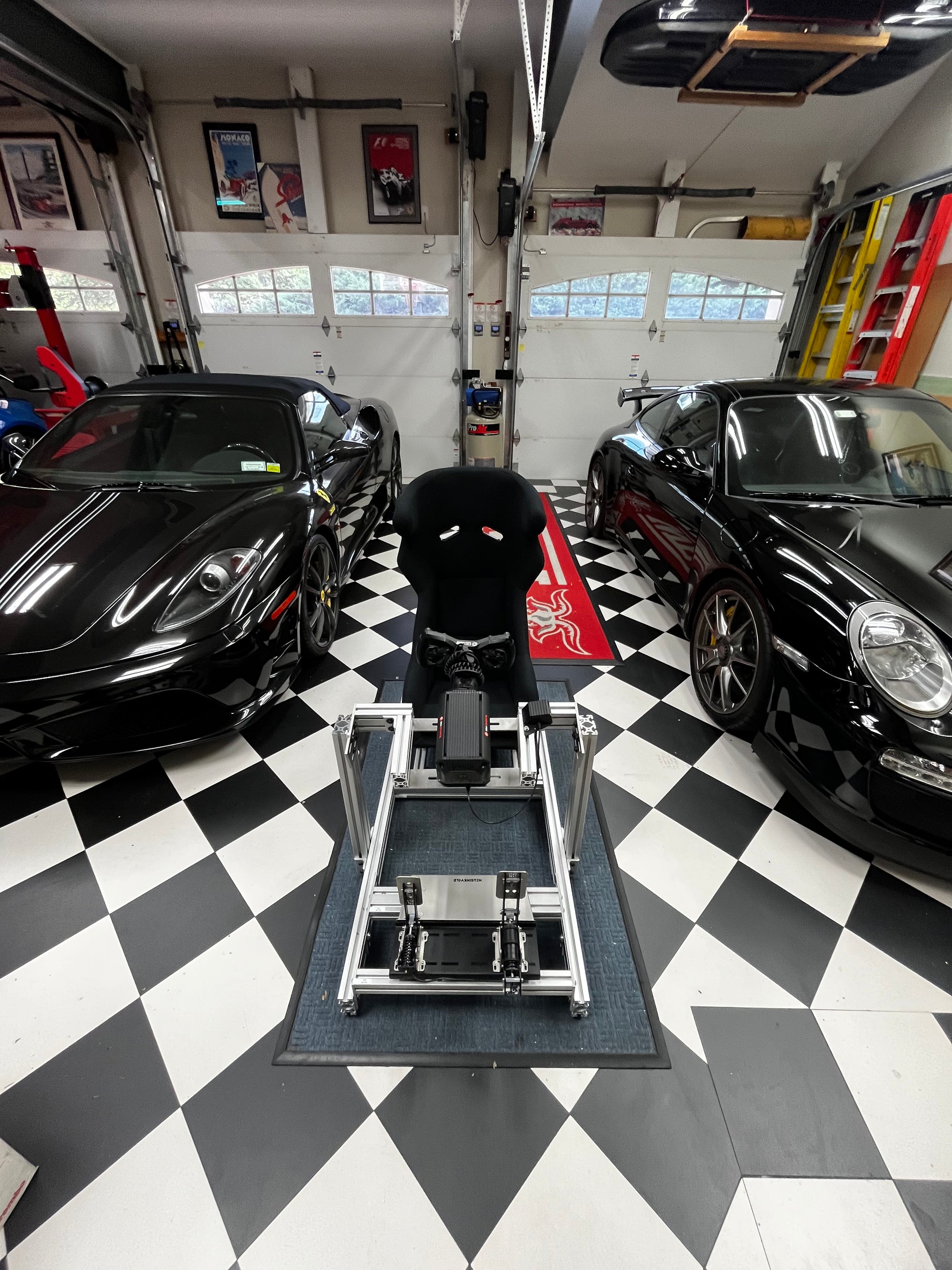 SRP GT100 ELITE sim racing chassis displayed beside a Ferrari and Porsche, showcasing its sleek design and professional-grade quality in comparison to high-performance race cars.