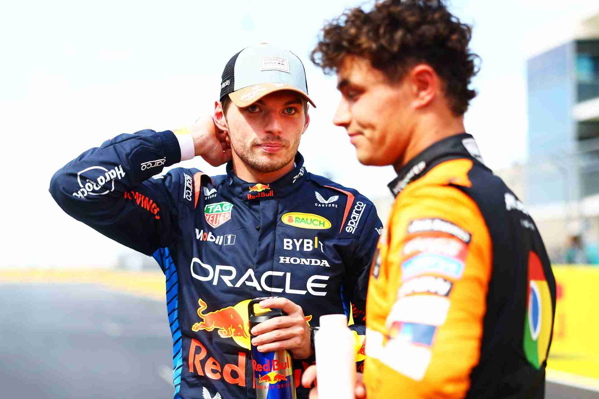 Lando Norris looking upset while standing next to Max Verstappen after the US Grand Prix, with Verstappen appearing calm and focused.